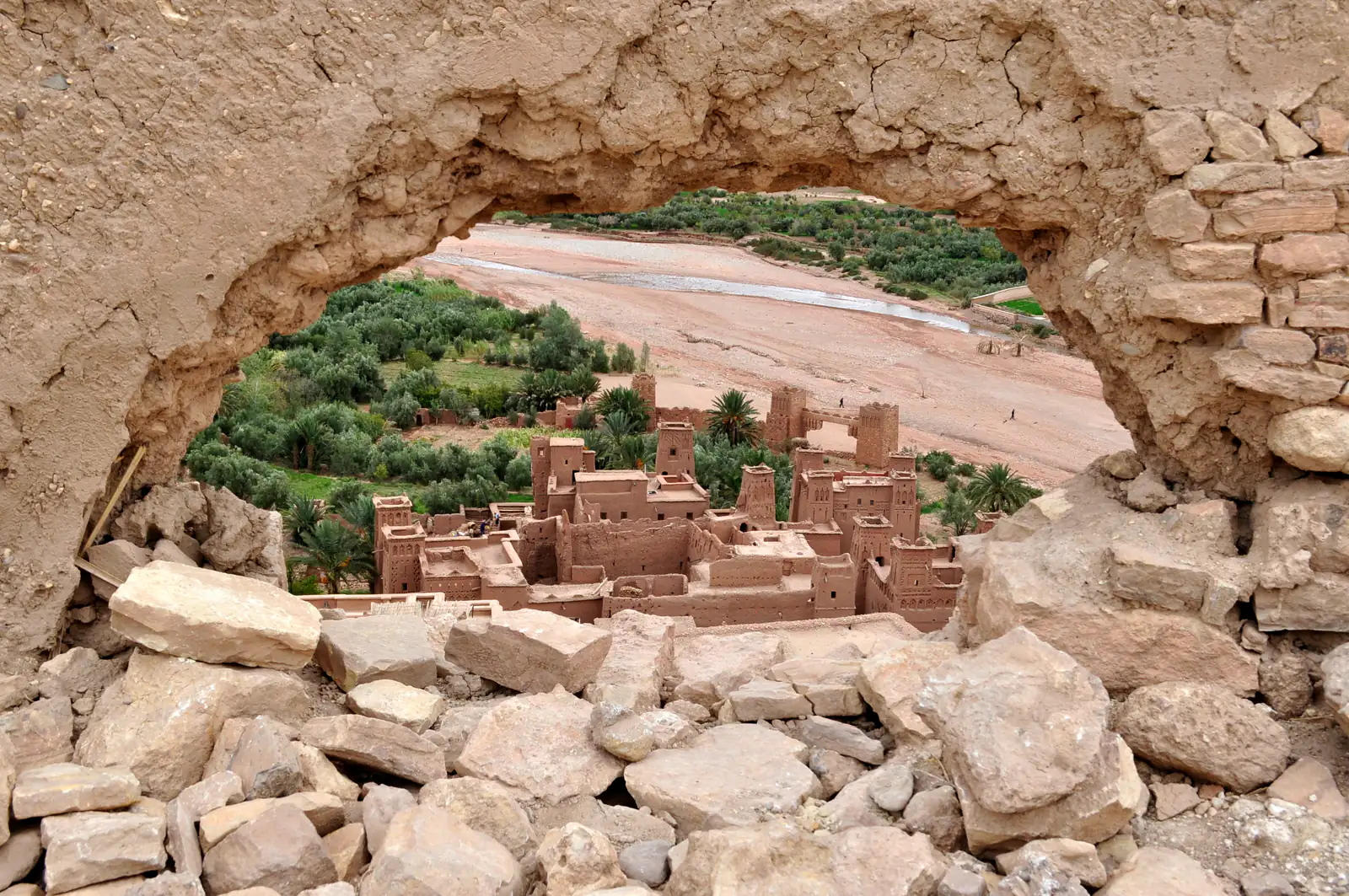 Lo ksar di Ait Ben Haddou e il fiume, visti dall'alto attraverso un varco in un muro di pietra