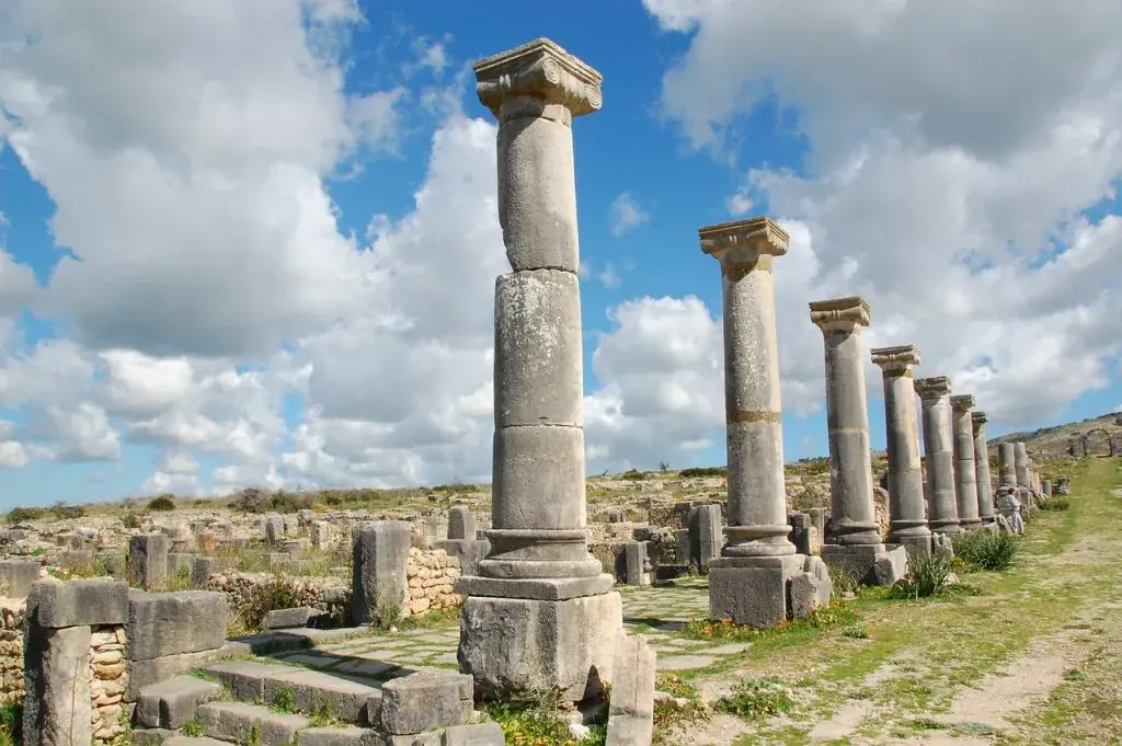 Fila di colonne romane a Volubilis sotto un cielo nuvoloso