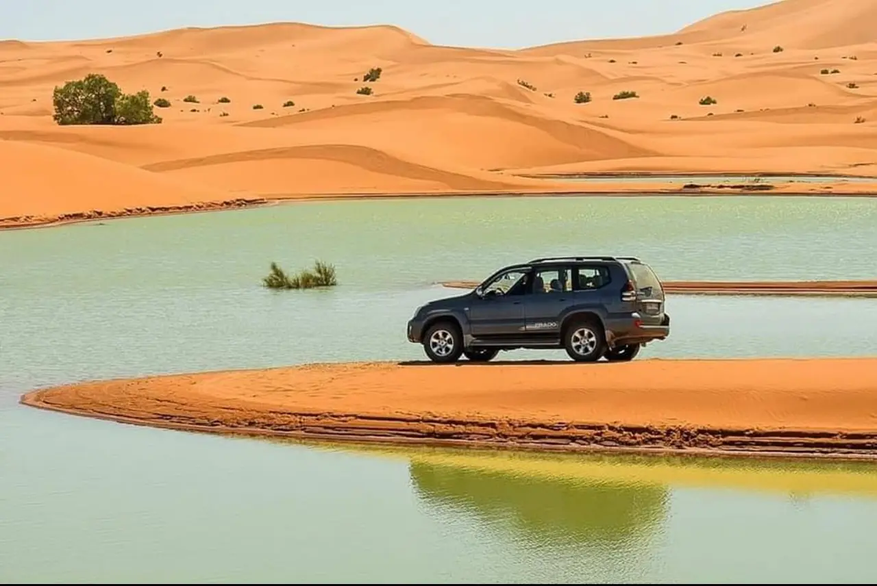 Fuoristrada 4x4 accanto a un lago tra le dune di Merzouga