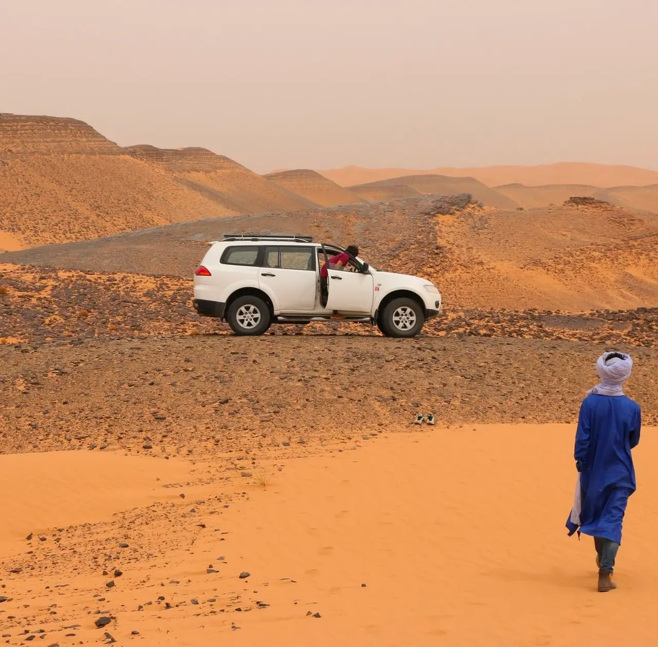 Fuoristrada bianco nel deserto di pietre, con una guida berbera