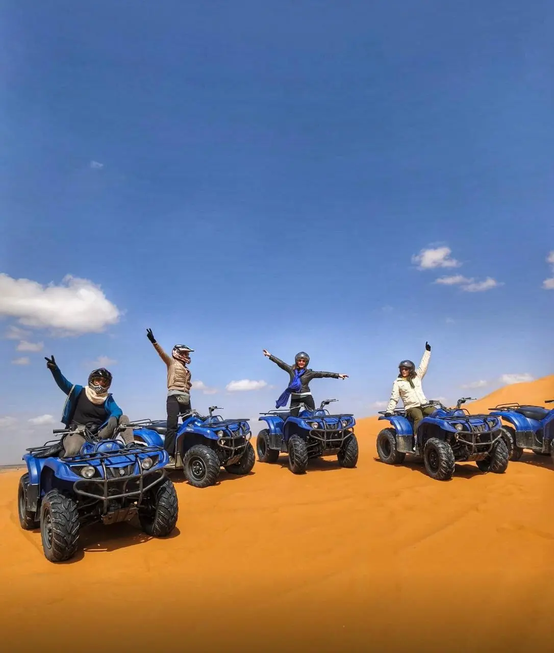 Gruppo che saluta dai quad sulle dune dell’Erg Chebbi
