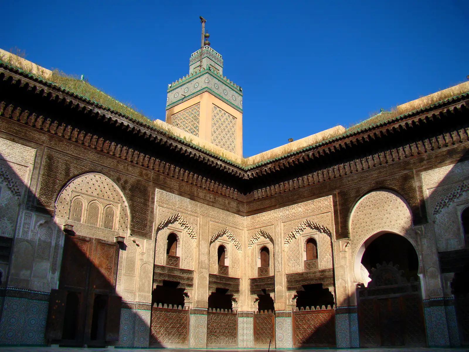 Il cortile e il minareto della madrasa Bou Inania a Fes, con archi di legno e stucco intagliati