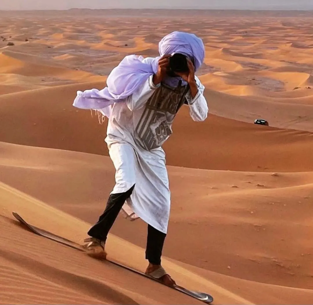 Guide descendant une dune en sandboard