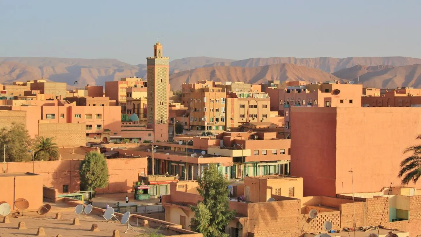 Veduta di Errachidia, con un minareto tra gli edifici e le montagne sullo sfondo